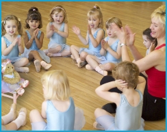 Jill Bridger and Melody Bear dancers sitting in a circle clapping