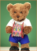 Photo of Milligan Bear driving a toy train with a rag doll across a mountain range