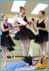 Senior ballet students creating a costume out of ribbons and flowers