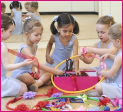 Photo of little ballerinas with ribbons, flowers, garlands and hoops