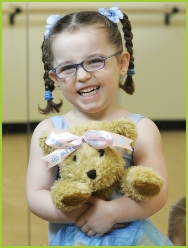 Photo of a pre-school dancer holding Melody Bear