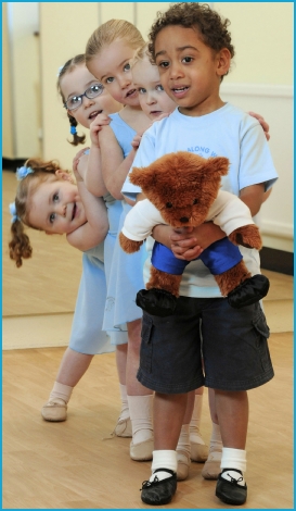 Girls and boys dancing with Milligan Bear