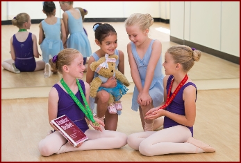 Ballet dancers looking at their medals